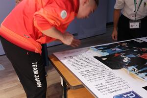 写真：サインを書く萩原選手