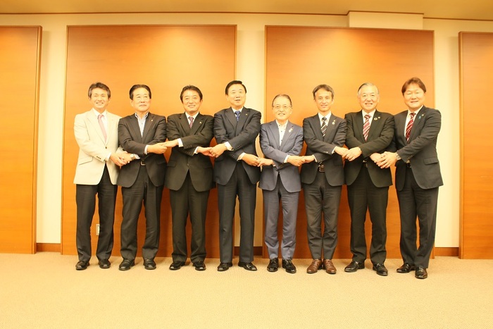写真：8市の市長たちによる握手の様子