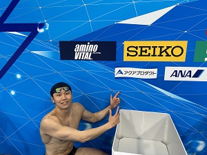 Photo: Player Yanagisawa taking a picture in front of Aqua Product
